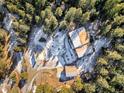 An aerial shot shows the layout of the home, surrounding trees, and detached garage at 636 Chute Rd, Golden, CO 80403