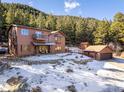 Beautiful multi-story home with a large garage, shed, balcony, and views of the surrounding pine forest at 636 Chute Rd, Golden, CO 80403