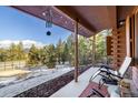 Inviting porch with views of the forest has seating and decorative hanging elements at 636 Chute Rd, Golden, CO 80403