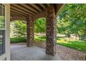 Covered outdoor patio featuring stone columns and a pebble ground cover at 8427 S Hoyt Way # 107, Littleton, CO 80128