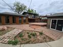 Backyard featuring a spacious deck, brick patio, and well-manicured landscaping at 902 S Potomac Way, Aurora, CO 80012