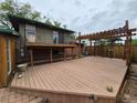 Large wooden deck perfect for outdoor entertaining, with a pergola and metal railing at 902 S Potomac Way, Aurora, CO 80012