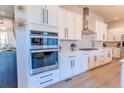 Modern kitchen with white cabinets, stainless steel appliances and double oven at 425 W 128Th Dr, Westminster, CO 80234