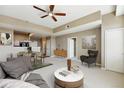 Open-concept living room with a ceiling fan, dining area, and view into the kitchen, creating a welcoming space at 7931 W 55Th Ave # 105, Arvada, CO 80002