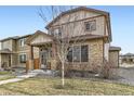 Beautiful two-story home boasts stone accents, a well-maintained lawn, and covered porch at 11769 Lovegrass Dr, Parker, CO 80138