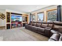 Media room with built-ins, large screen TV and plush leather sofa for cozy relaxation at 1324 State Highway 66, Longmont, CO 80504