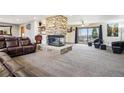Spacious living room boasting a stone fireplace, neutral carpeting, and backyard access at 1324 State Highway 66, Longmont, CO 80504