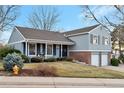 Charming two-story home featuring a two-car garage, front porch, and landscaped front yard at 6918 E Easter Pl, Centennial, CO 80112