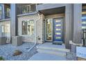 Close-up view of the front entrance, featuring a stylish blue door and modern address numbers at 16555 Peak Way, Broomfield, CO 80023