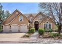 Charming home featuring a three-car garage, stone accents, and a landscaped front yard at 7420 S Wolff St, Littleton, CO 80128