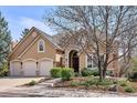 Charming home featuring a three-car garage, stone accents, and a landscaped front yard at 7420 S Wolff St, Littleton, CO 80128