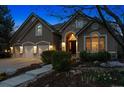 Charming home featuring a three-car garage, stone accents, and a manicured front yard at 7420 S Wolff St, Littleton, CO 80128
