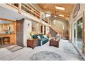Cozy living room featuring a wood-burning fireplace, vaulted ceilings, log railing, and lots of natural light at 11182 S Barney Gulch Rd, Conifer, CO 80433