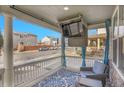 Relaxing front porch with a mounted TV and a view of the neighborhood street at 3406 Purcell St, Brighton, CO 80601