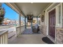 Cozy front porch with outdoor seating, a mounted TV, and blue privacy curtains at 3406 Purcell St, Brighton, CO 80601