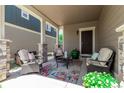 Inviting front porch with stylish wicker furniture and a colorful rug, perfect for relaxing outdoors at 23757 Eagle Bend Ln, Parker, CO 80138