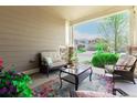 Cozy front porch seating area with comfortable chairs, a glass table, and views of the neighborhood at 23757 Eagle Bend Ln, Parker, CO 80138