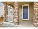 Charming front porch with stone columns and a welcoming entrance to the home at 17859 E 108Th Pl, Commerce City, CO 80022