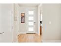 Bright entryway with hardwood floors and a modern front door with frosted glass panels at 1333 Raleigh St, Denver, CO 80204