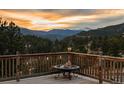 Scenic deck view overlooking lush greenery and distant mountains, perfect for outdoor relaxation at 127 Granite Way, Evergreen, CO 80439