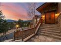 Inviting front entrance with stone steps leading to double wooden doors and a picturesque view at 127 Granite Way, Evergreen, CO 80439