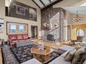 Inviting living room with a stone fireplace, elegant furnishings, and stunning views, creating a warm and luxurious atmosphere at 127 Granite Way, Evergreen, CO 80439