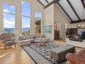 Bright and airy living room with vaulted ceilings, large windows showcasing scenic views, and a stylish seating arrangement at 127 Granite Way, Evergreen, CO 80439