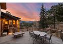 Charming outdoor dining area on a spacious deck with views of the surrounding landscape at 127 Granite Way, Evergreen, CO 80439