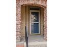 Inviting front entryway with decorative door, brick archway, and wrought iron railings at 10650 Ashfield St, Highlands Ranch, CO 80126