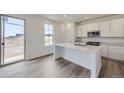 A modern kitchen featuring white cabinets, stainless steel appliances, and a central island with a sink at 15153 W Dequesne Ave, Morrison, CO 80465