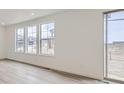 Bright living room with hardwood floors, white walls, and multiple windows offering plenty of natural light at 15153 W Dequesne Ave, Morrison, CO 80465