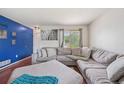 Cozy living room featuring a large sectional sofa and lots of natural light at 19707 E Caspian Cir, Aurora, CO 80013