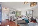 Bright living room featuring a large sectional sofa and wood flooring at 19707 E Caspian Cir, Aurora, CO 80013