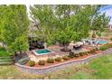 Lovely outdoor living area with hot tub, landscaping, and stone accents at 7818 S Zeno St, Centennial, CO 80016