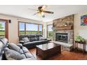 Cozy living room with stone fireplace, hardwood floors, and large windows showcasing the scenic view at 984 Shadow Mountain Dr, Highlands Ranch, CO 80126