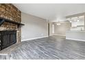 Spacious living room with stone fireplace flowing into an open floor plan with wood-look floors at 1777 S Pitkin St # A, Aurora, CO 80017