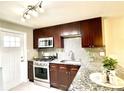 Updated kitchen featuring stainless steel appliances, granite countertops, and dark wood cabinets at 4816 W 8Th Ave, Denver, CO 80204