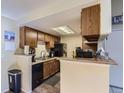 Functional kitchen features wood cabinets and black appliances with breakfast bar at 18193 E Kentucky Ave # 203, Aurora, CO 80017