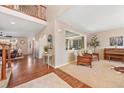 Open-concept living room featuring hardwood floors, large windows, and comfortable seating area at 7765 Yankee Ct, Arvada, CO 80007