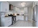 Bright kitchen features stainless steel appliances, white cabinets, subway tile backsplash, and hexagon tile floors at 5191 S Logan St, Littleton, CO 80121