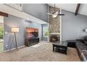 Open living room with vaulted ceilings, brick fireplace and carpeted floors at 17162 E Atlantic Pl, Aurora, CO 80013