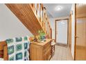 Well lit foyer featuring a wooden staircase, tile floor, and convenient access to the entry door and other rooms at 4863 Silver Spruce Ln, Evergreen, CO 80439
