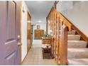 Inviting foyer with tile flooring, wooden staircase, and decor that provide a warm and welcoming atmosphere at 4863 Silver Spruce Ln, Evergreen, CO 80439