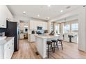 Bright, modern kitchen with white cabinets, stainless steel appliances, and a center island with seating, open to the dining area at 3373 N Catawba Way, Aurora, CO 80019