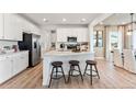 Modern kitchen with white cabinets, stainless steel appliances, a large center island, and stylish bar stools, perfect for casual dining at 3373 N Catawba Way, Aurora, CO 80019