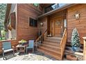 Charming front entry with a wood door, stone patio, and comfortable seating area at 4407 Delaware Dr, Larkspur, CO 80118