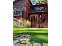 Beautiful front exterior of a wood home featuring mature landscaping and a stone walkway at 4407 Delaware Dr, Larkspur, CO 80118