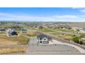 Expansive aerial view of neighborhood with white fencing and mountain backdrop at 16197 Paris Way, Brighton, CO 80602