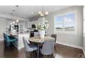 A dining area complemented by an eat-in kitchen island, with sunlit windows at 16197 Paris Way, Brighton, CO 80602