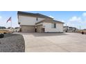 This home features a three-car garage with an extra-long driveway, fenced perimeter and manicured gravel landscaping at 16197 Paris Way, Brighton, CO 80602